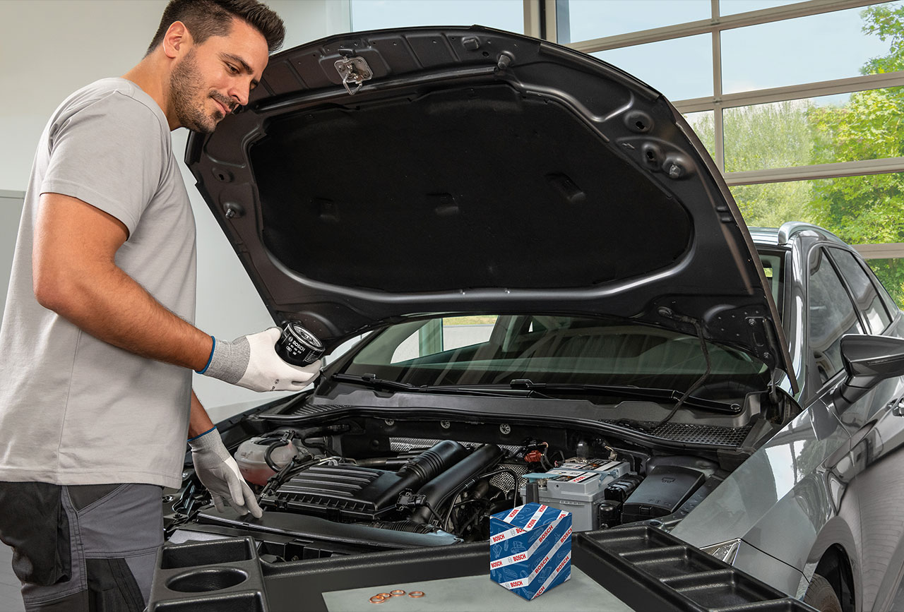 Man working under hood of vehicle