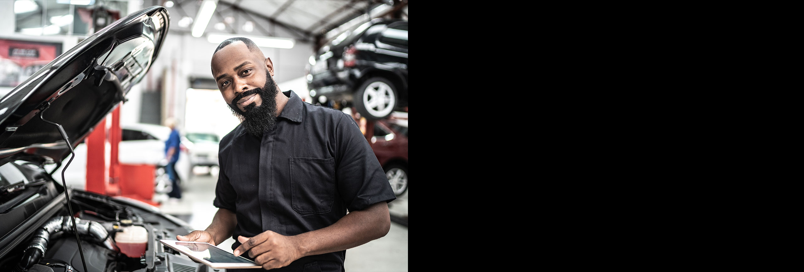 Man working under hood of vehicle